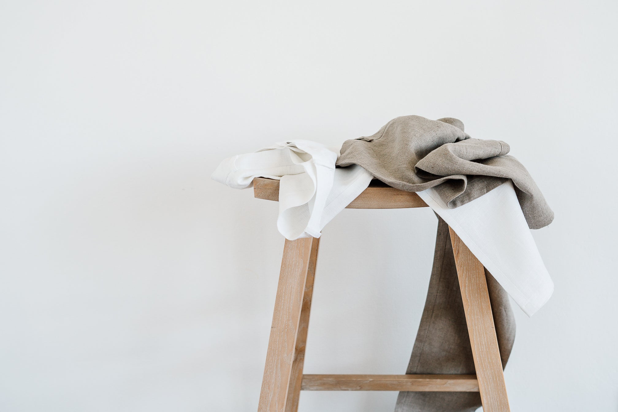 linen pants on wood stool against white a wall